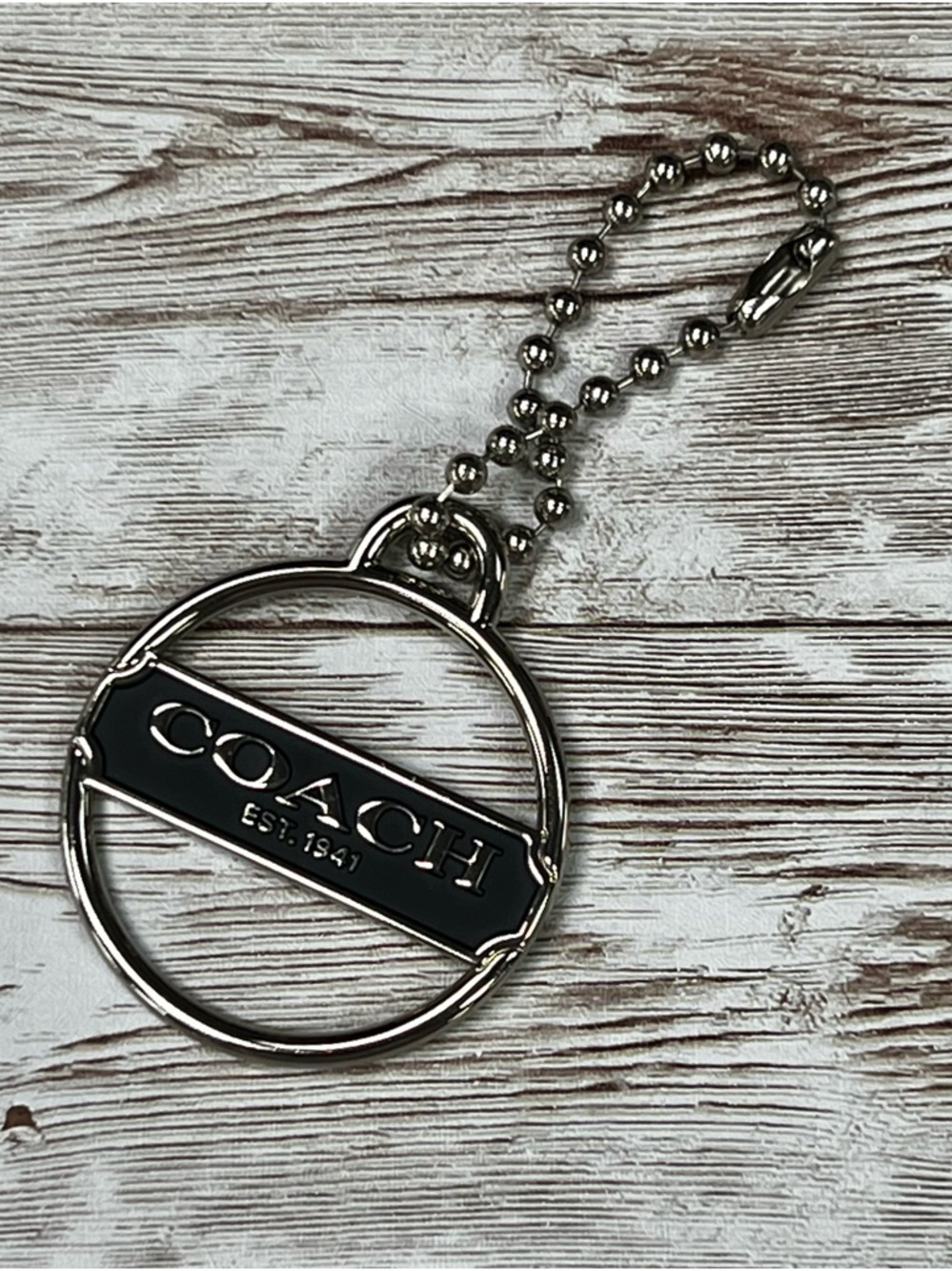 Coach Silver-Tone Round Hang Tag with Black Logo Plaque